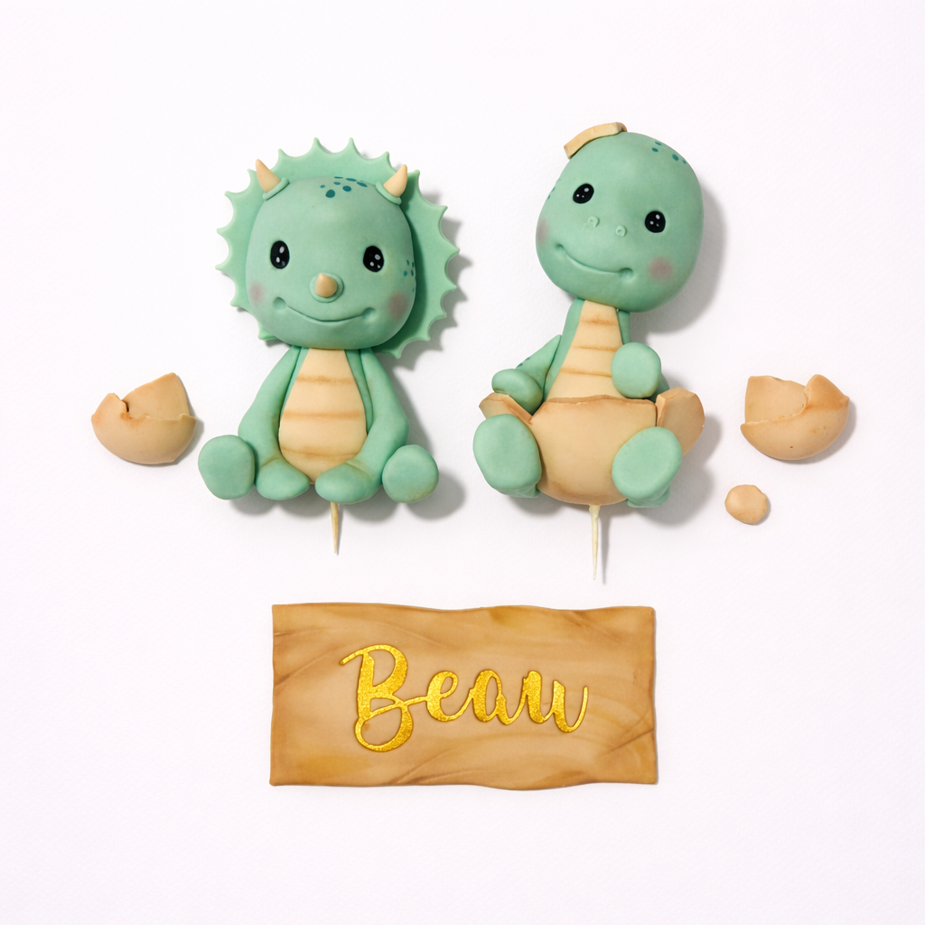 2 Fondant dinosaur cake toppers with egg shell pieces and personalised name plaque