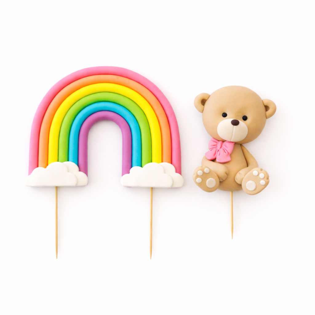 Rainbow and teddy bear cake toppers on sticks against a white background